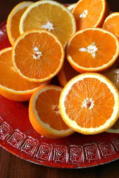 Naranjas a la mitad en un plato rojo —  Fotos de Stock