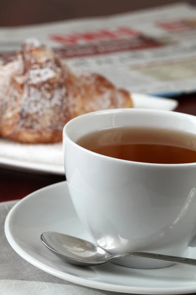 Tea, croissant and newspaper — Stock Photo, Image