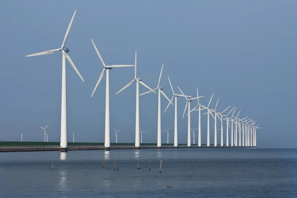 Řada větrných mlýnů, odráží v holandské moře — Stock fotografie