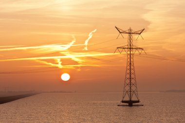 Sunrise over the Dutch sea with an electricity pylon clipart