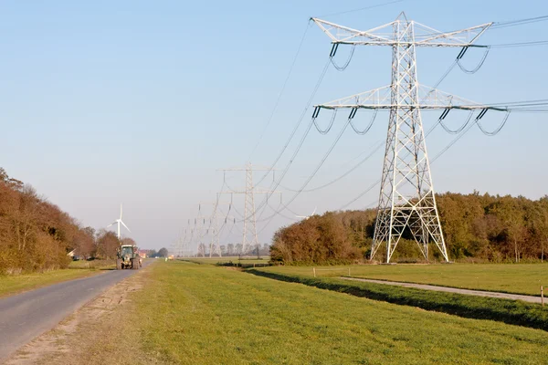 Kraftledningsstolparna i nederländska jordbruksmark — Stockfoto
