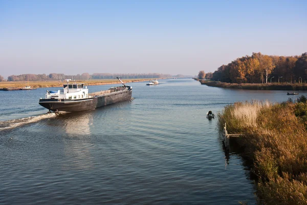 Большой голландский канал с рыбаками и грузовым судном — стоковое фото