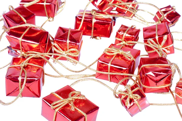 Kette von kleinen dekorativen Weihnachtsgeschenken an einem goldenen Seil — Stockfoto