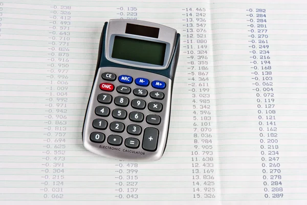 Calcolatrice con una copia cartacea di cifre tabulari — Foto Stock