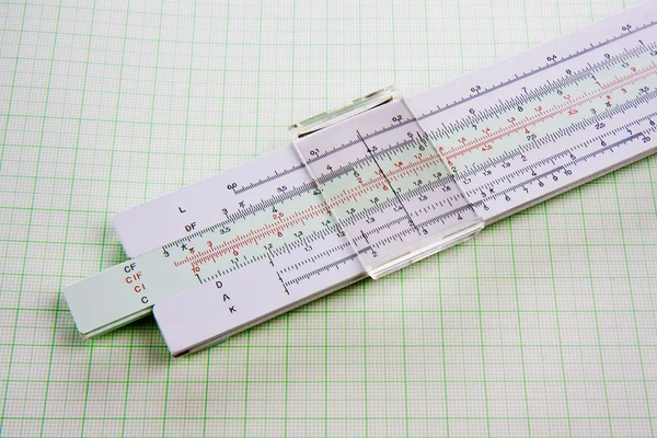 stock image Old used slide rule on squared paper