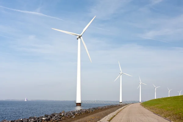 Ветряные турбины, стоящие вдоль дамбы в Голландском море — стоковое фото