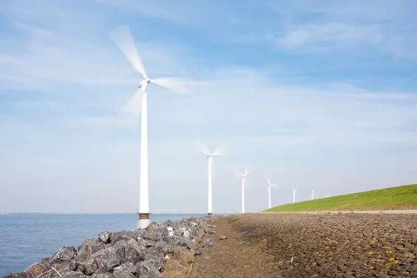 Spinning windturbines standing in the sea photographed with long — Stock Photo, Image