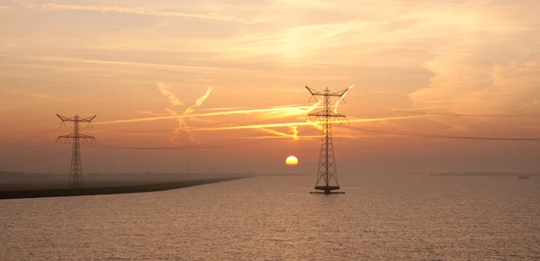 Zonsopgang boven de Nederlandse zee met het silhouet van twee elektriciteit — Stockfoto