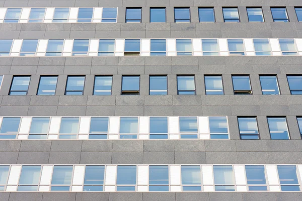 Fasaden på en modern kontorsbyggnad med symmetriska glasfönster — Stockfoto