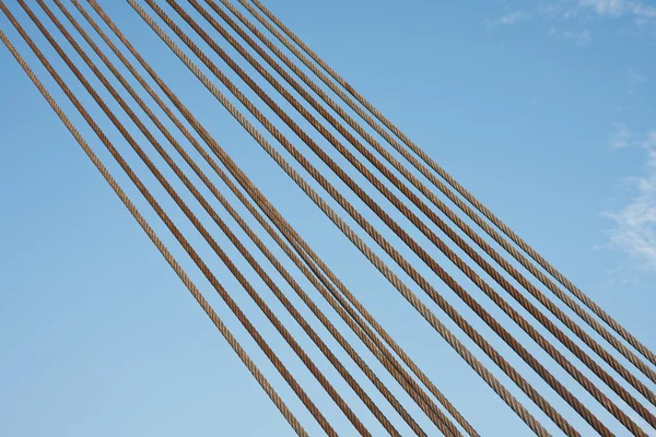 Conjunto de cabos de aço contra um céu azul — Fotografia de Stock