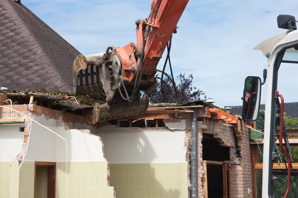 Förstörelsen av en byggnad av en caterpillar crane — Stockfoto