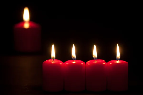 Conjunto de velas rojas encendidas en la oscuridad con enfoque selectivo —  Fotos de Stock