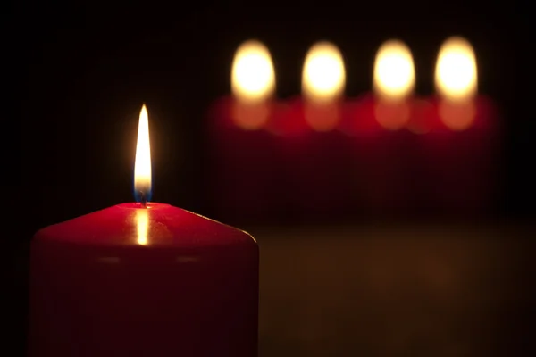 Conjunto de velas vermelhas queimando no escuro com foco seletivo — Fotografia de Stock