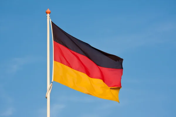 Немецкий флаг, дующий на ветру против голубого неба — стоковое фото