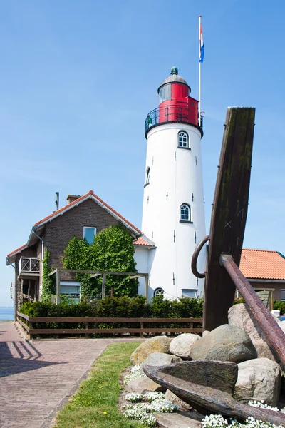 Dutch lighthouse with a big anchor in front of it — Stock Photo, Image