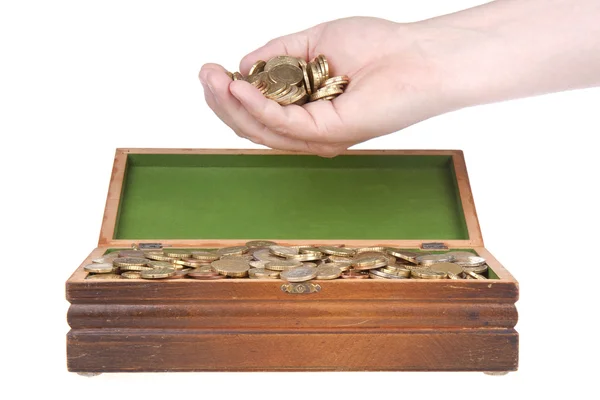 Hand vol munten over een schatborst — Stockfoto