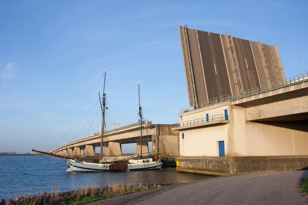 Nave a vela che passa un ponte di cemento aperto — Foto Stock