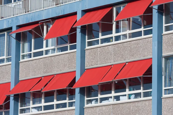 Fachada de un edificio con sombrillas rojas —  Fotos de Stock