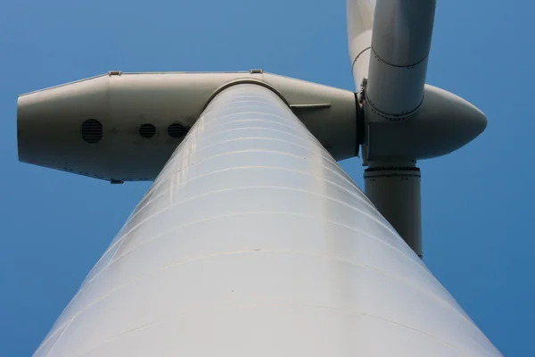 In piedi ai piedi di un'enorme turbina eolica — Foto Stock