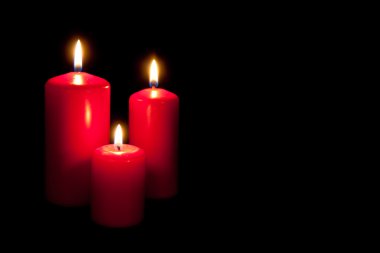 Set of three red candles burning in the dark clipart