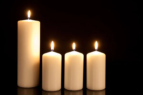 Vier weiße Kerzen auf schwarz — Stockfoto