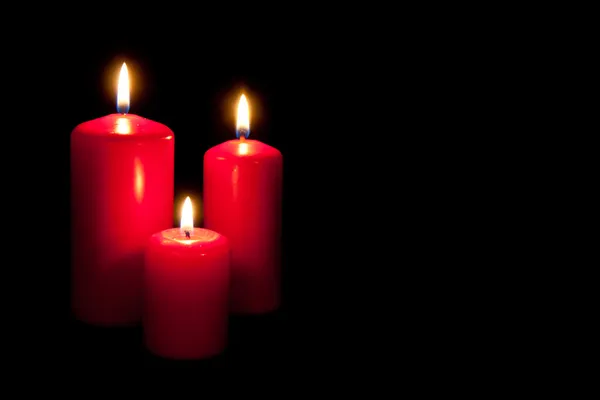 Conjunto de três velas vermelhas queimando no escuro — Fotografia de Stock