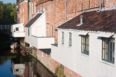 Historic Dutch city with wooden house extensions above the canal clipart