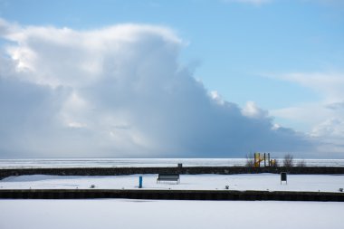 Frozen Dutch harbor in winter covered with snow while a giant th clipart