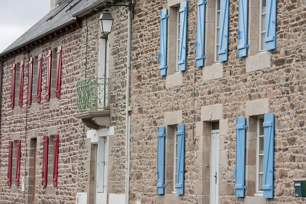 Фасад традиційних бетонних будинків з червоними і синіми віконницями — стокове фото