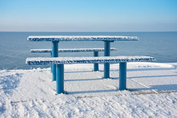 Besneeuwde picknicktafel en bankje langs de Nederlandse kust — Stockfoto
