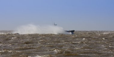 Lifeboat at full speed in stormy weather clipart