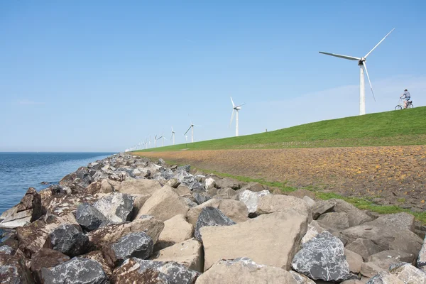 Endless dike with windmills with lonely bicycle — Stock Photo, Image