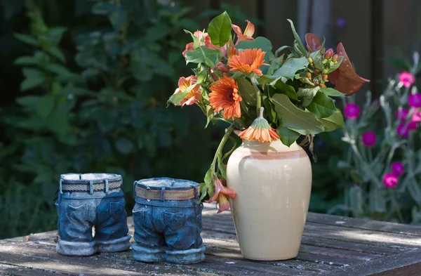 Ainda vida de vasos e flores em uma mesa de jardim — Fotografia de Stock