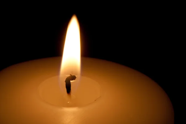 Detail einer brennenden Kerze im Dunkeln — Stockfoto