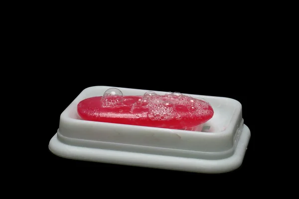 stock image Soap dish with bubbles covered soap on black