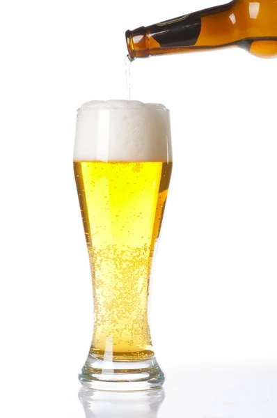 Birra versata dalla bottiglia in vetro isolato su bianco — Foto Stock