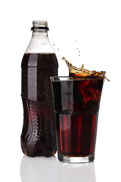 Butelkę i kieliszek cola z rozchlapać — Zdjęcie stockowe