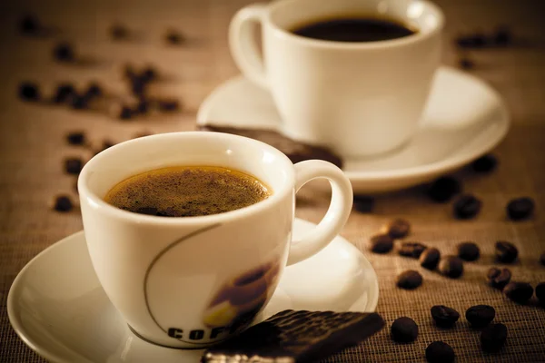 Кофейные чашки шоколадные конфеты и кофейные зёрна — стоковое фото