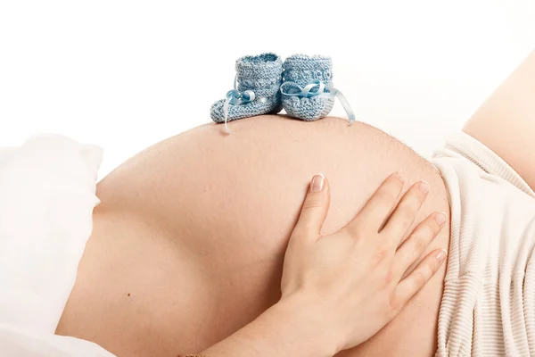 Bootees on pregnang belly — Stock Photo, Image
