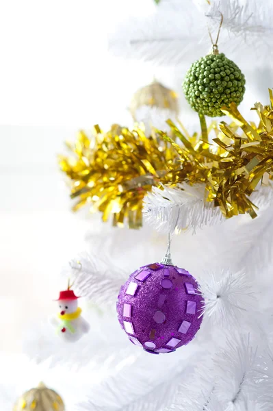 Baubles e pequeno boneco de neve em uma árvore de Natal — Fotografia de Stock