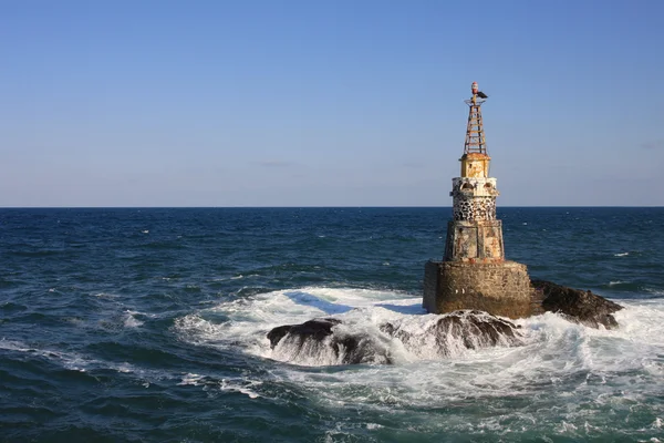 stock image The lighthouse in the sea.