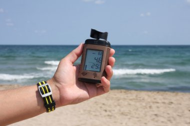 Measuring wind speed on the beach. clipart