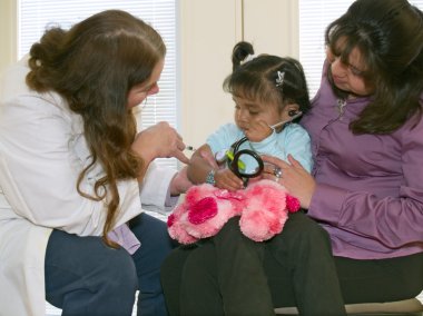 Doctor vaccinating a little Native American girl clipart