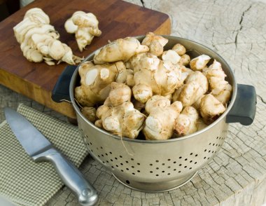 Jerusalem artichokes in a colander clipart