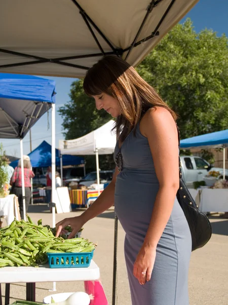 Mujer hispana embarazada comprando verduras —  Fotos de Stock
