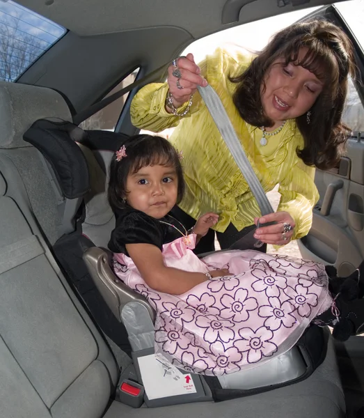 Chica nativa americana en un asiento de seguridad para niños —  Fotos de Stock