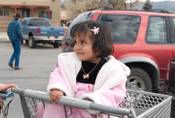 Söt Indian flicka sitter i en shoppingvagn — Stockfoto