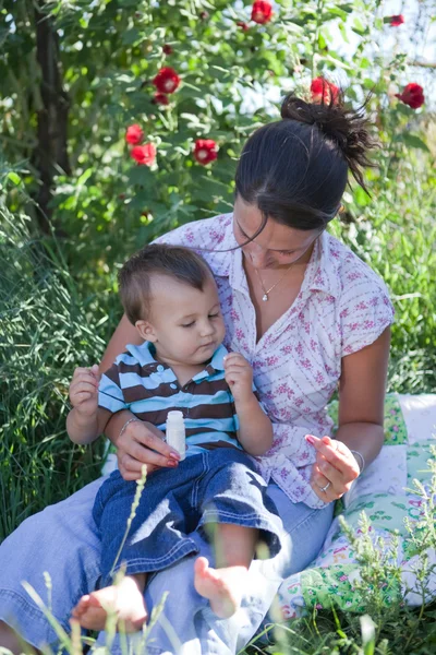 Moeder homeoptahic geneeskunde te geven aan haar zoon — Stockfoto