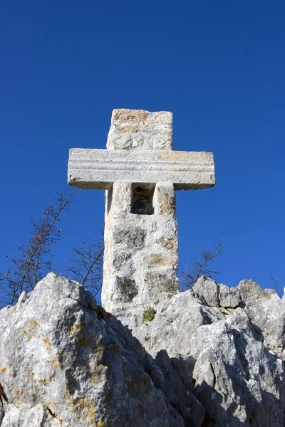 Каменный крест на голубом небе — стоковое фото