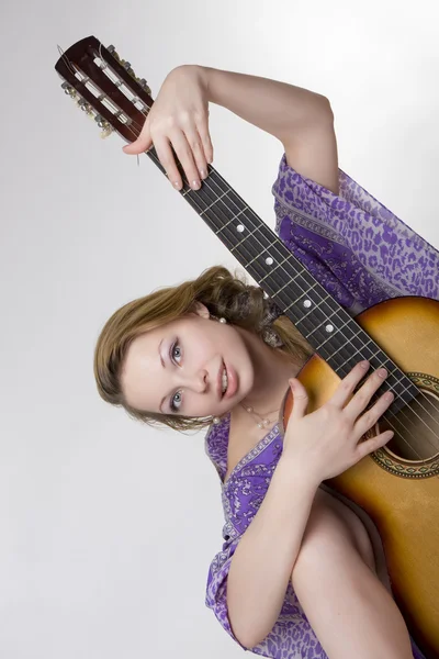 Красивая девушка, которая играет на гитаре — стоковое фото